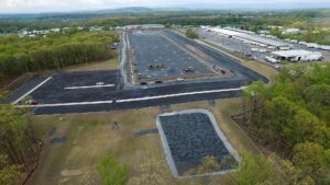 An alternate aerial view of the Maybrook Logistics Warehouse construction site showing paved access roads around the warehouse foundation.