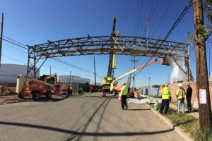 Overhead utility system constructed from steel box trusses being installed.
